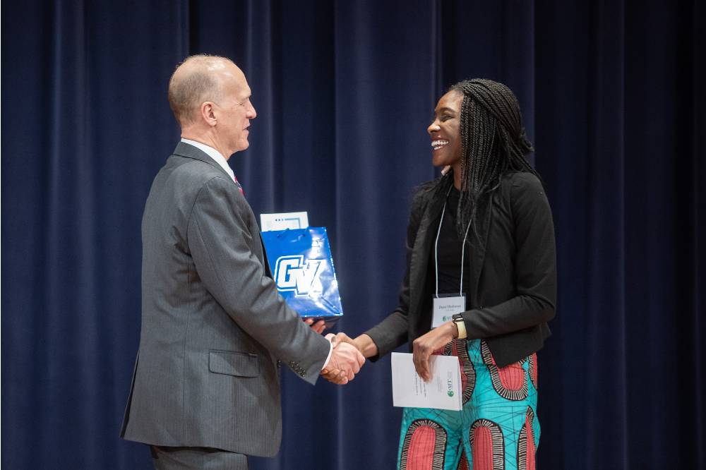 Dean Potteiger shaking hands with a student winner